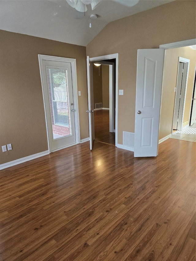 empty room featuring ceiling fan, dark hardwood / wood-style flooring, and vaulted ceiling