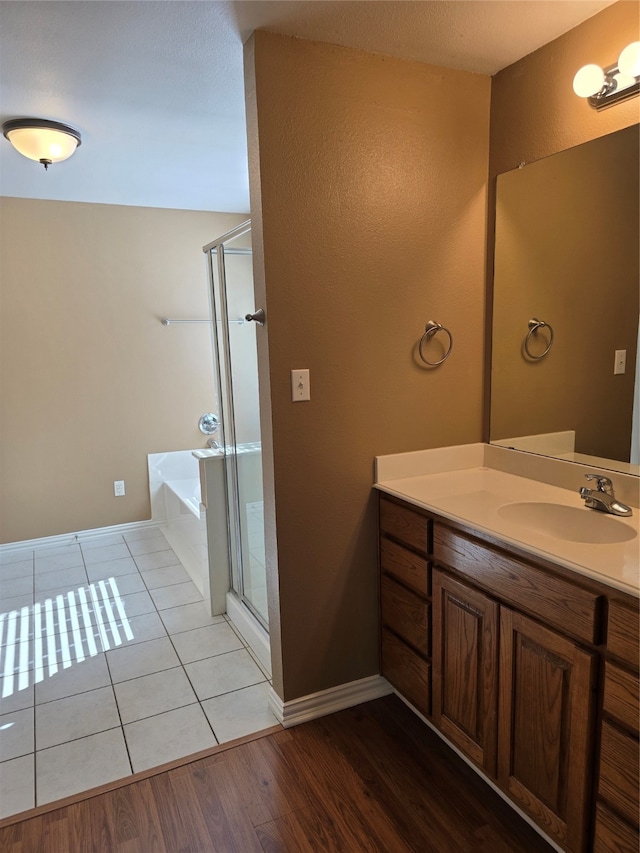 bathroom with wood-type flooring, independent shower and bath, and vanity