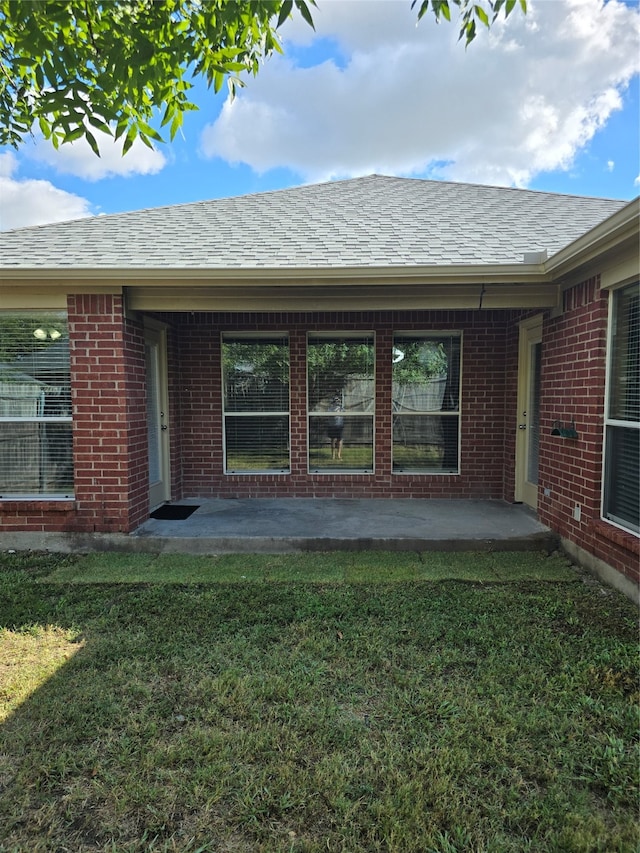 back of property with a patio area and a yard