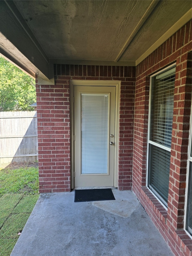 view of exterior entry with a patio area