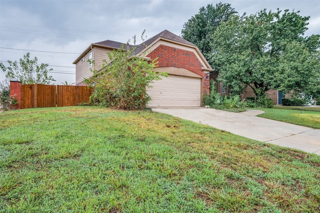 view of property hidden behind natural elements with a garage and a front yard