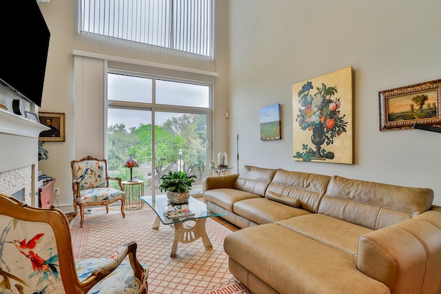 living room featuring a tiled fireplace and a towering ceiling