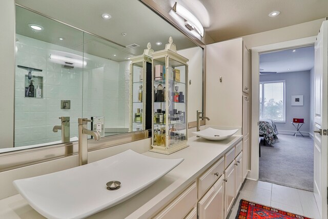 bathroom with tile patterned floors, tiled shower, and vanity