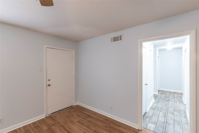 unfurnished room featuring a textured ceiling, ceiling fan, and hardwood / wood-style flooring