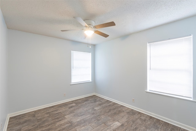 spare room with a textured ceiling, ceiling fan, and dark hardwood / wood-style floors