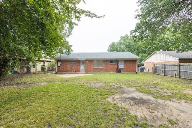 rear view of house with cooling unit, a lawn, and a patio