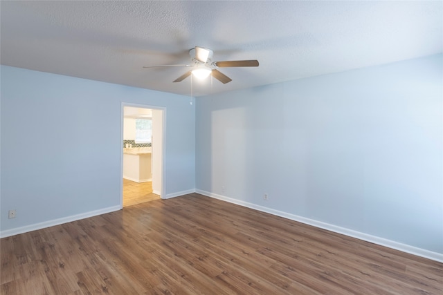 unfurnished room with ceiling fan, hardwood / wood-style flooring, and a textured ceiling