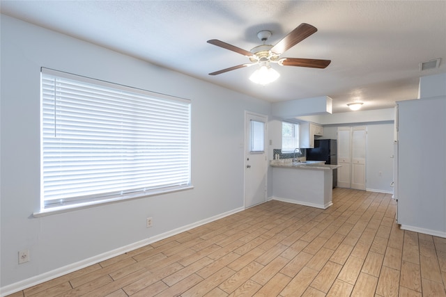 kitchen featuring light wood-type flooring, ceiling fan, kitchen peninsula, and white cabinetry