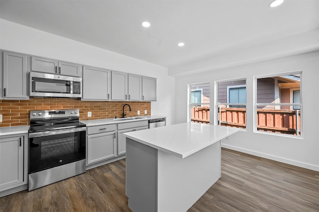 kitchen featuring stainless steel appliances, gray cabinetry, and dark hardwood / wood-style floors