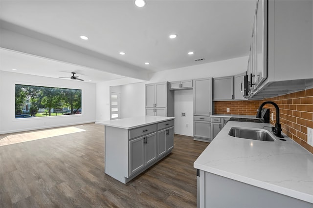 kitchen with a center island, ceiling fan, gray cabinetry, and sink