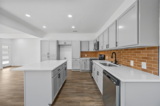 kitchen featuring a kitchen island, dark hardwood / wood-style flooring, appliances with stainless steel finishes, sink, and gray cabinets