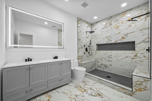 bathroom with tiled shower, vanity, and toilet