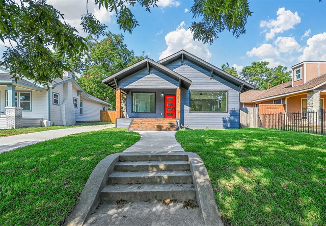bungalow-style home featuring fence and a front lawn