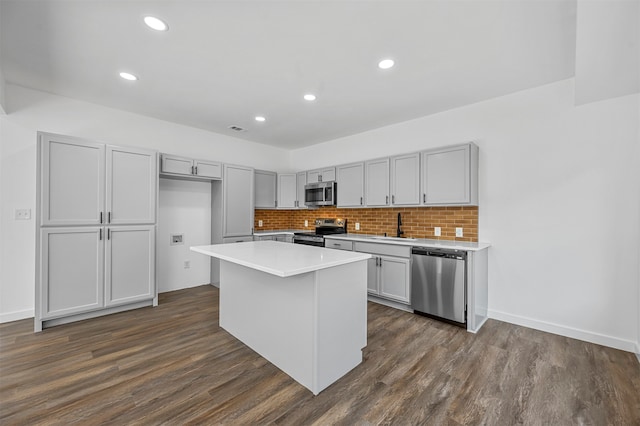 kitchen featuring a center island, gray cabinetry, appliances with stainless steel finishes, and dark hardwood / wood-style floors