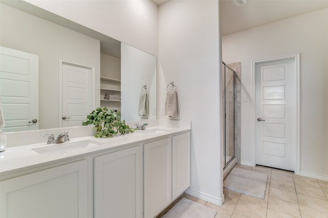 bathroom featuring tile patterned flooring, a shower with door, and vanity