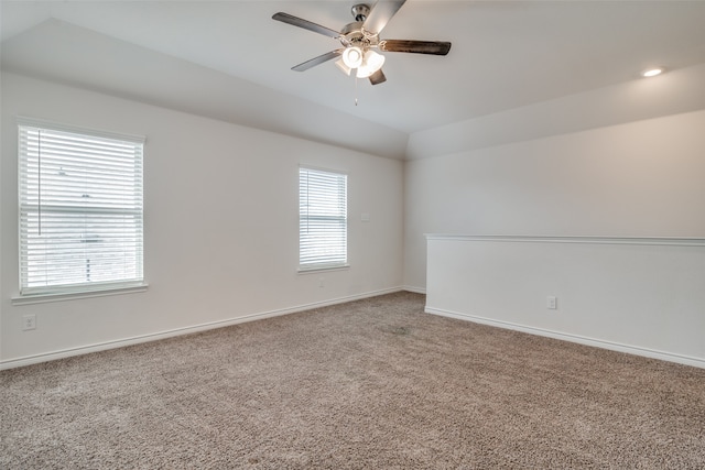 spare room featuring a healthy amount of sunlight, ceiling fan, carpet floors, and vaulted ceiling