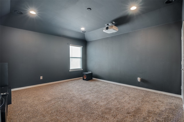 carpeted spare room featuring lofted ceiling