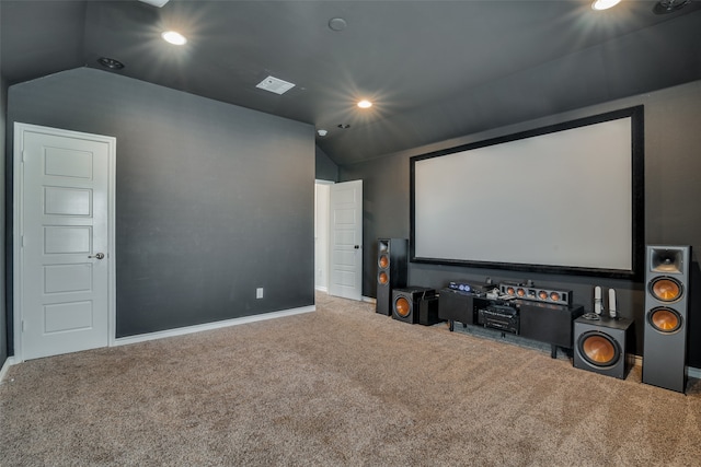 carpeted home theater room featuring vaulted ceiling