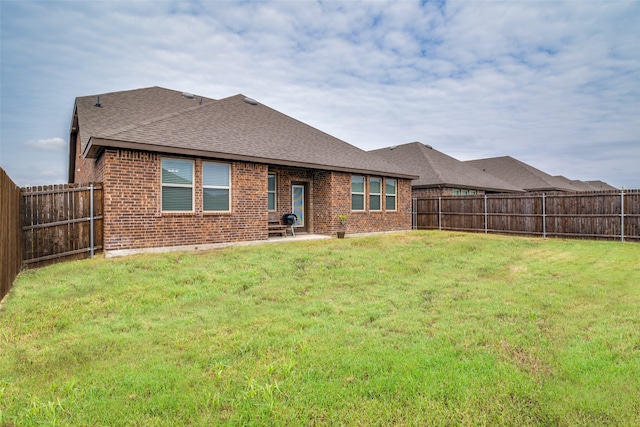 back of house featuring a patio area and a yard