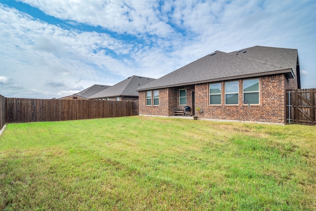 rear view of property with a lawn and a patio