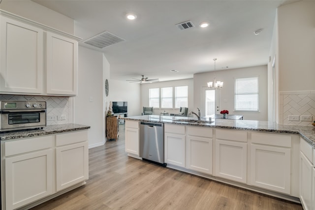 kitchen featuring ceiling fan with notable chandelier, dishwasher, plenty of natural light, and sink