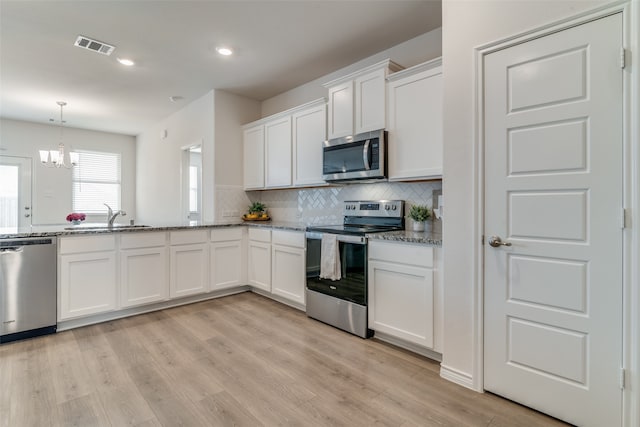 kitchen with white cabinetry, sink, light stone countertops, appliances with stainless steel finishes, and light hardwood / wood-style floors