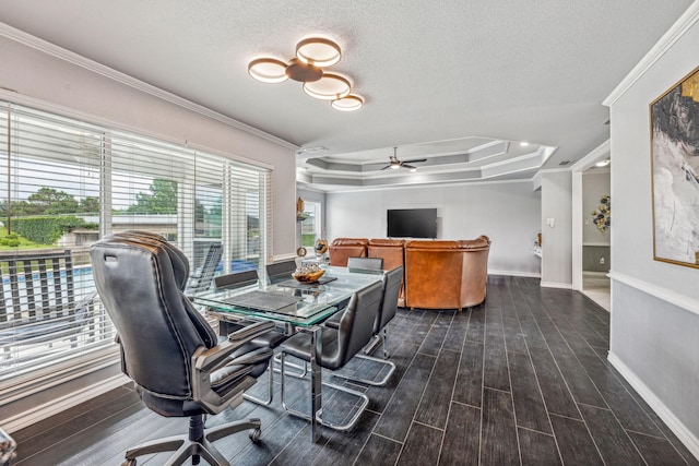 dining room with ornamental molding, a textured ceiling, dark hardwood / wood-style flooring, ceiling fan, and a tray ceiling