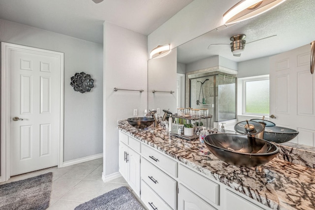 bathroom featuring walk in shower, tile patterned floors, vanity, a textured ceiling, and ceiling fan