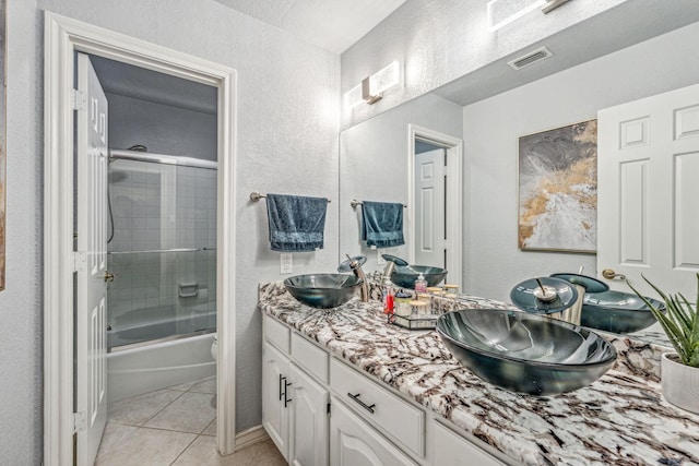 full bathroom with vanity, toilet, tile patterned floors, and bath / shower combo with glass door