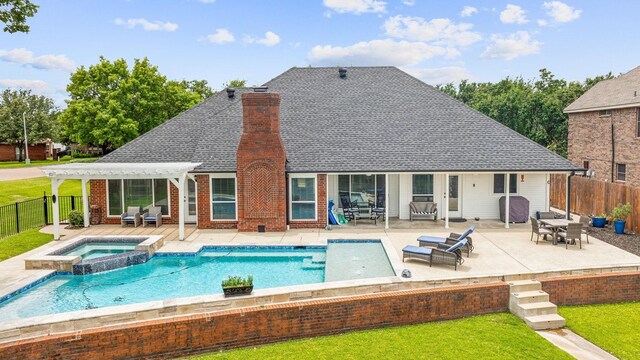 rear view of house featuring a patio area and a pool with hot tub