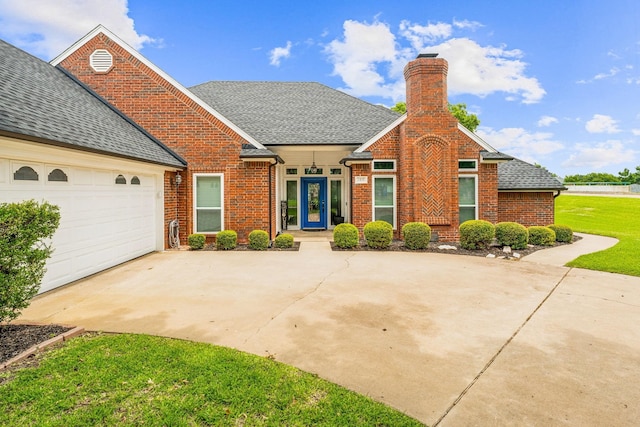 view of front of house featuring a garage, a front lawn, and french doors