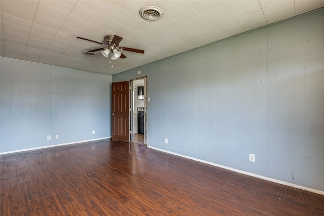 empty room with a ceiling fan, baseboards, visible vents, and wood finished floors