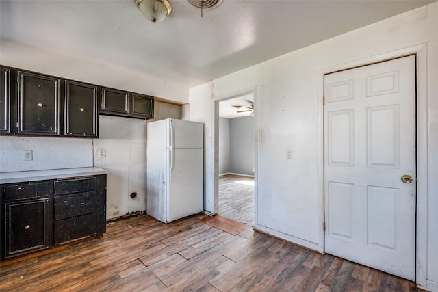 kitchen with light countertops, visible vents, freestanding refrigerator, wood finished floors, and dark cabinets