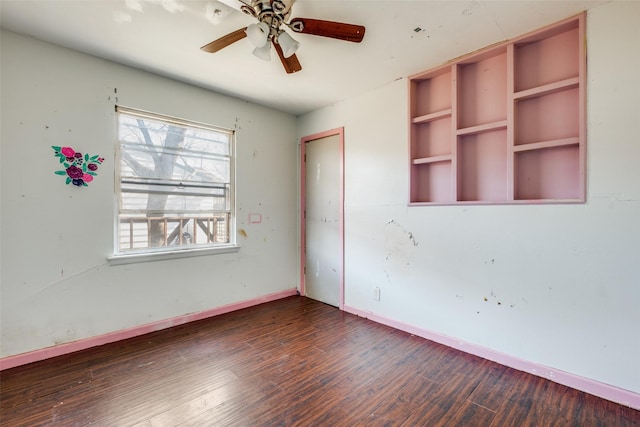 unfurnished room featuring wood finished floors, a ceiling fan, and baseboards