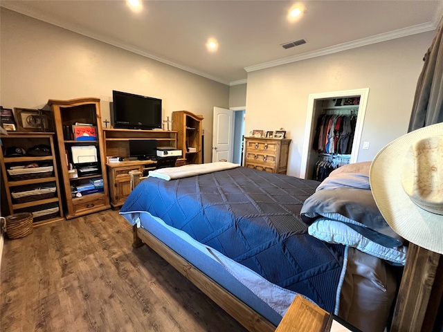 bedroom with dark wood-type flooring, ornamental molding, a closet, and a spacious closet