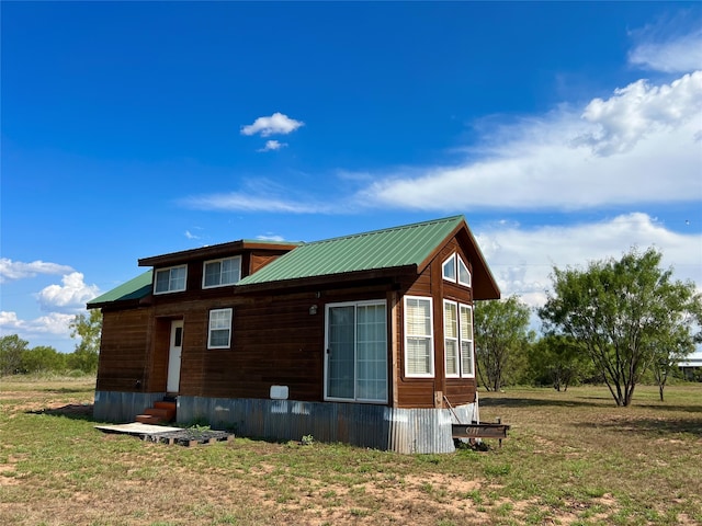 view of side of home with a yard