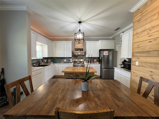 dining room featuring crown molding, sink, dark hardwood / wood-style floors, and a chandelier