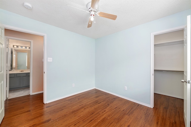 unfurnished bedroom with a closet, ceiling fan, dark hardwood / wood-style flooring, and a textured ceiling