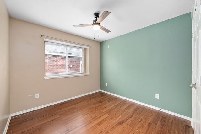 empty room with hardwood / wood-style floors and ceiling fan