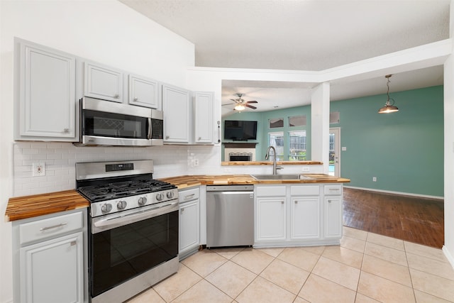 kitchen featuring white cabinets, stainless steel appliances, light hardwood / wood-style floors, sink, and butcher block counters