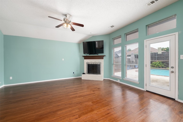 unfurnished living room featuring lofted ceiling, hardwood / wood-style floors, ceiling fan, and a brick fireplace