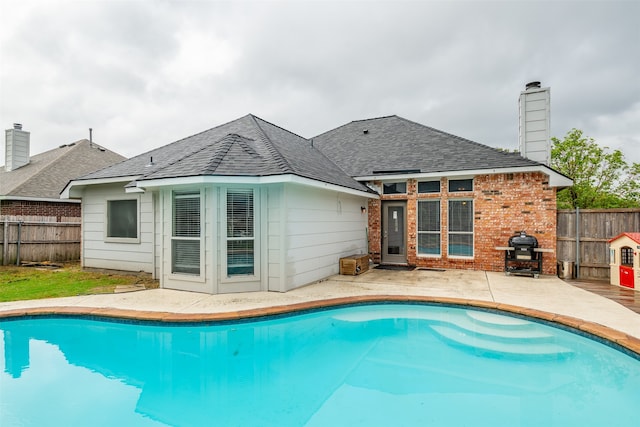 view of pool featuring a grill and a patio