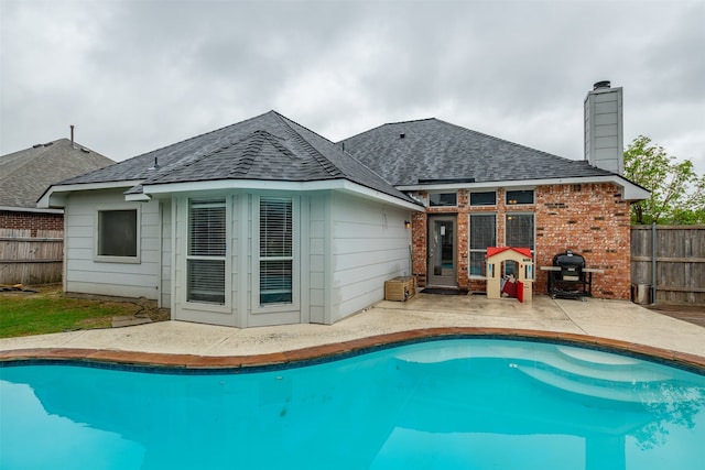 view of pool with grilling area and a patio