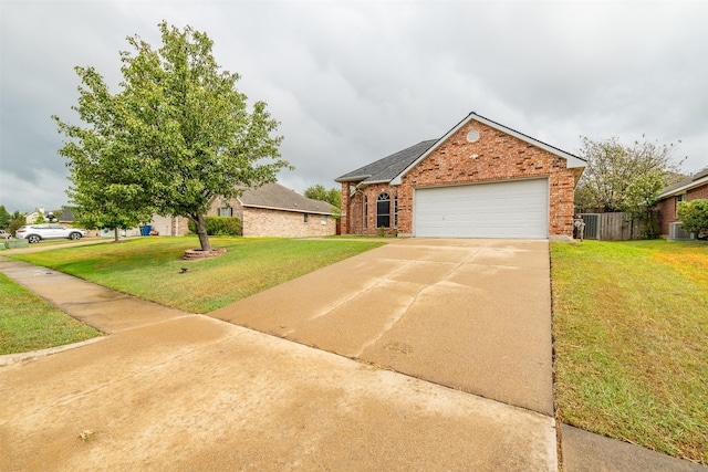 view of front of house featuring cooling unit, a garage, and a front lawn