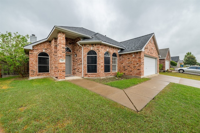 view of front of property with a garage and a front lawn