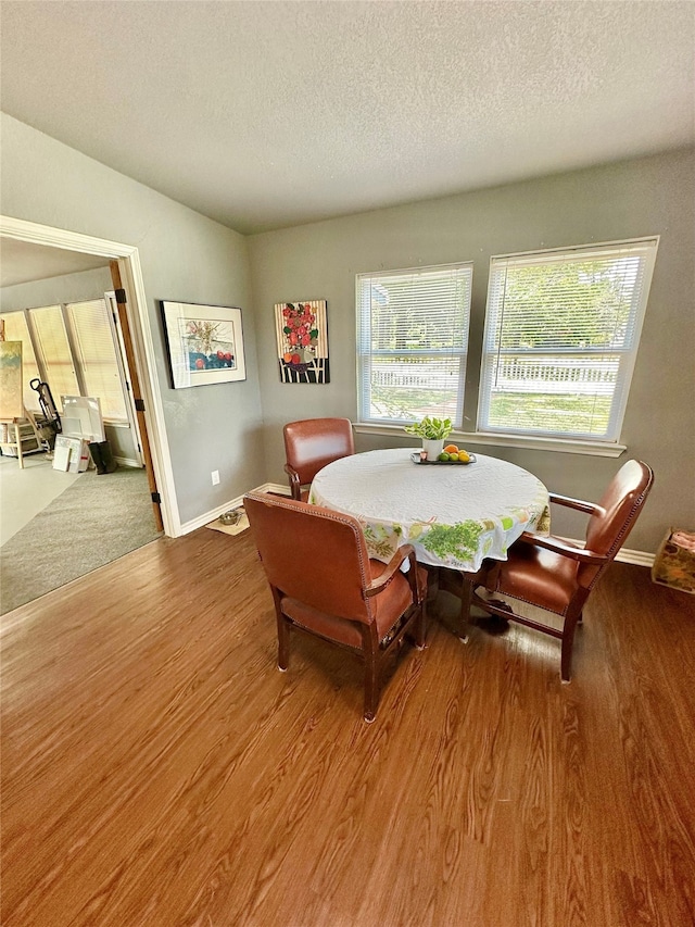 dining space with a textured ceiling and wood-type flooring