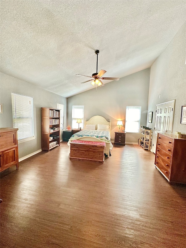 bedroom with lofted ceiling, dark wood-type flooring, ceiling fan, and a textured ceiling