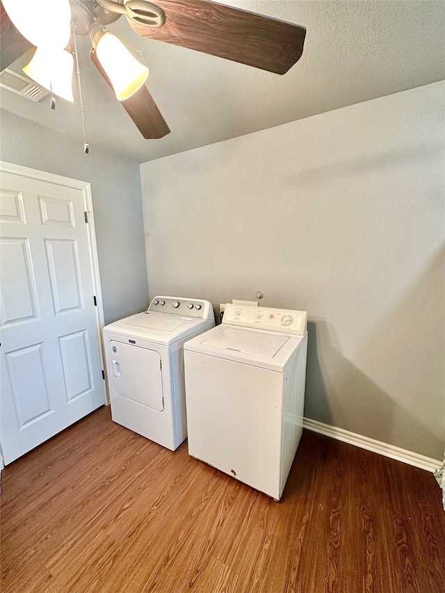 clothes washing area with a textured ceiling, washer and clothes dryer, ceiling fan, and light wood-type flooring