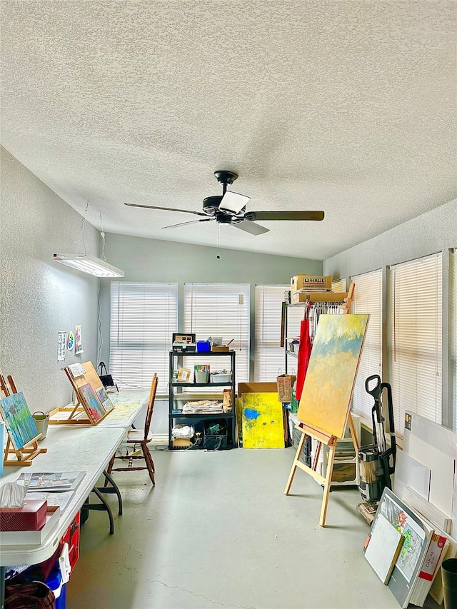 interior space with a textured ceiling, ceiling fan, and concrete flooring