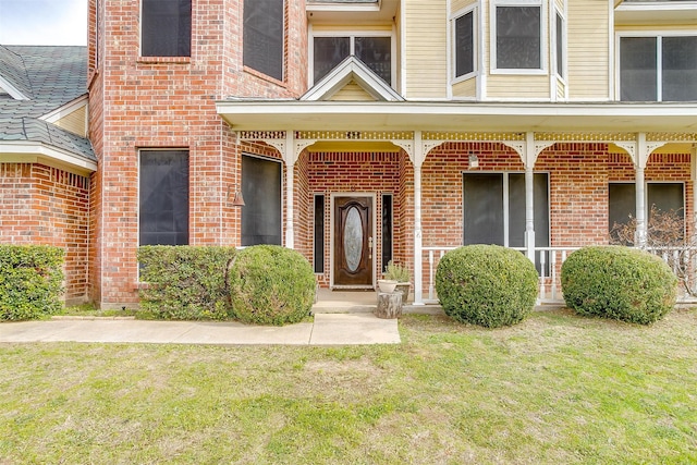 view of exterior entry featuring a lawn